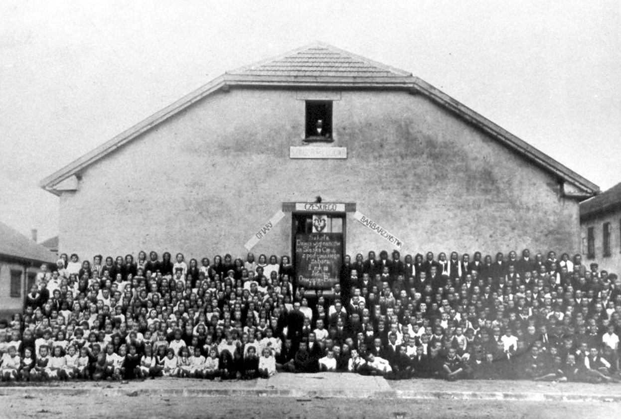 Dzieci Polaków wysiedlonych z Zaolzia przed budynkiem szkoły na terenie osady barakowej w Oświęcimiu (źródło: Archiwum PMA-B)