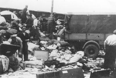 syg.GK-9-1-42-171, Więźniowie porządkują przywiezione przez samochód ciężarowy mienie pozostałe po przybyciu transportu Żydów z Węgier(?). Autor: Hoffmann E. - plutonowy SS, Walter B. - starszy sierżant SS. Źródło AIPN.
