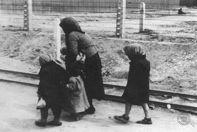 Starsza kobieta z trójką małych dzieci z transportu Żydów z Węgier (?) po selekcji w drodze z rampy bocznicy kolejowej w obozie zagłady KL Auschwitz-Birkenau do krematorium. Źródło AIPN