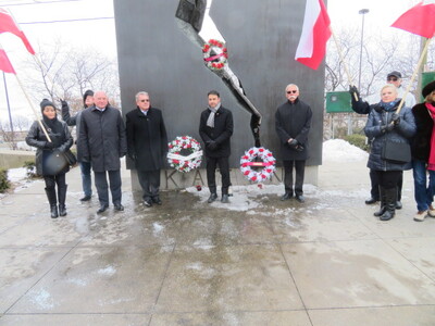 Delegacja IPN w Kanadzie – 14–17 lutego 2018. Złożenie kwiatów pod Pomnikiem Katyńskim w Toronto. Drugi od lewej konsul generalny Krzysztof Grzelczyk, obok wiceprezes IPN Jan Baster i sekretarz parlamentarny Ministerstwa Dziedzictwa Arif Virani oraz przedstawiciele Polonii