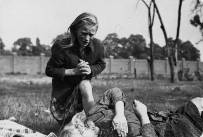 Dwunastoletnia Kazimiera Kostewicz (Mika) nad ciałem zabitej siostry Anny zabitej w ataku lotniczym na polu w  pobliżu skrzyżowania ulic Ostroroga i Wawrzyszewskiej w Warszawie. (AIPN/Kolekcja Juliena Bryana w Warszawie)