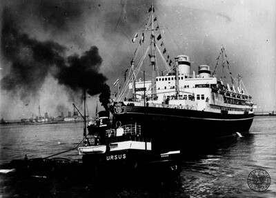 Statek pasażerski m/s „Batory” podczas wyprowadzania z portu w Gdyni przez holownik „Ursus”. W tle (z lewej) widoczny hulk szkoleniowy ORP „Bałtyk”. Przed II wojną, wolna Polska, lata 30. XX w. Fot. z zasobu IPN (kolekcja: Andrzej Kapłański).