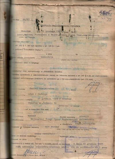 Fot. 2. Skanogram karty z akt zalanych - żółty kwasny papier z odbitymi i rozmytymi zapisami pisma ręcznego, rozmytymi krawędziami stempla, w górnej części karty - czarne nieregularne slady rozwoju grzyba na powierzchni i w masie papierowej. AIPN Wr 18/57 t. 26, s. 28.