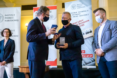 Pamiątkę po Franciszku Czaplickim (zegarek kieszonkowy) odbierają z rąk prezesa IPN Jarosława Szarka przedstawiciele rodziny – Andrzej Czaplicki i Kamil Kaczyński – Warszawa, 14 czerwca 2021. Fot. Sławek Kasper (IPN)