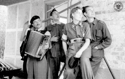 Grupa powstańców na terenie willi Brodziszów przy ulicy Malczewskiego. Pierwszy z lewej ppor. Wacław Żdżarski ps. „Kozłowski” (z harmonią) (fotoreporter BiP). Pierwszy z prawej por. Jan Markowski ps. „Krzysztof” (twórca muzyki do „Marszu Mokotowa” oraz twórca innej powstańczej piosenki „Sanitariuszka Małgorzatka”). Obok niego (druga z lewej) sanitariuszka Janina Załęska ps. „Małgorzatka” (sanitariuszka Pułku AK „Baszta”, bohaterka powstańczej piosenki „Sanitariuszka Małgorzatka”). (AIPN)