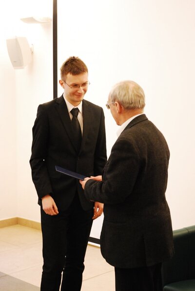 Bartłomiej Kapica odbiera nagrodę z rąk prof. Andrzeja Paczkowskiego