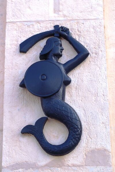 Detal bramy – Syrenka Warszawska – zaczerpnięty z odznaki 2. Korpusu Polskiego. Fot. Adam Siwek 2015