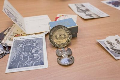 Na pierwszym planie odznaka z napisem Policja Państwowa Służba Śledcza, za nią w pudełku sygnet z herbem Ślepowron. Fot. Katarzyna Adamów