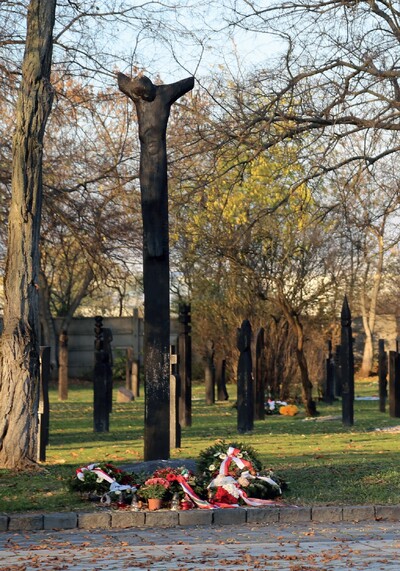 Pomnik polsko-węgierskiej solidarności 1956 roku – Chrystus z odciętymi rękoma; w tle drewniane nagrobki Imrego Nagya, Pála Malétera i Miklósa Gimesa w kształcie kopii wbitych drzewcem w ziemię. Fot.: Arkadiusz Gołębiewski