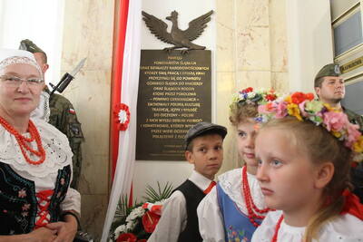 Mieszkańcy w strojach ludowych na tle tablicy. Fot. „Dziennik Zachodni”
