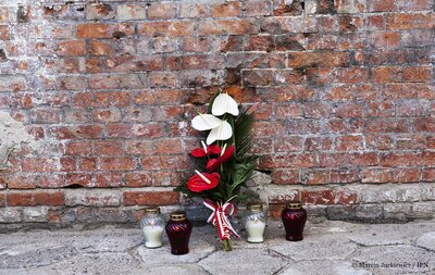 Kwiaty i znicze pod ścianą straceń w Muzeum Żołnierzy Wyklętych i Więźniów Politycznych PRL – 29 sierpnia 2017. Fot. Marcin Jurkiewicz / IPN