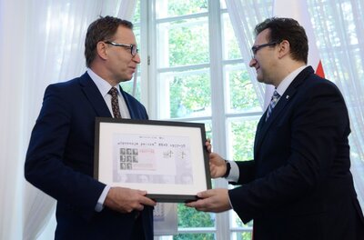 Prezes IPN Jarosław Szarek i wiceprezes Poczty Polskiej S. A. Wiesław Włodek prezentują znaczek pocztowy upamiętniający ofiary operacji antypolskiej NKWD – Warszawa, Belweder, 29 września 2017. Fot. PAP/Jacek Turczyk