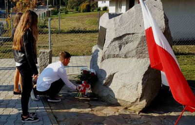 Złożenie kwiatów przy pamiątkowym głazie we wsi Groszki