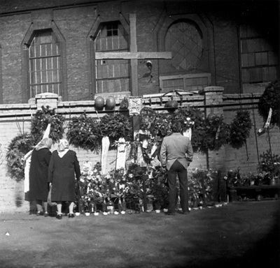 Wieńce i kwiaty złożone pod  drewnianym krzyżem upamiętniającym poległych górników KWK Wujek,
 zdjęcie niedatowane. sygn. akt IPN Ka 435/8