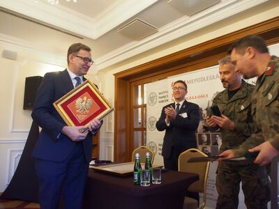 Prezes IPN dr Jarosław Szarek odbiera pamiątkowy obraz orła białego oraz odznakę Jednostki Strzeleckiej 2036 im. Oddziału Partyzanckiego Armii Krajowej „Błysk” z Paradyża