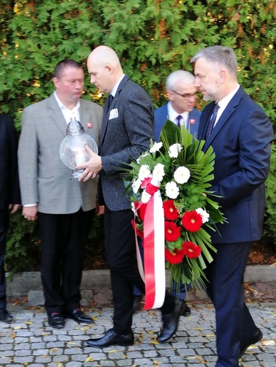 Składanie zniczy i kwiatów pod Ścianą Śmierci