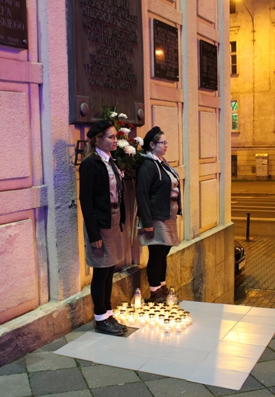 Składanie zniczy pod tablicą upamietniającą Ofiary Gestapo, które ucierpiały w budynku Domu Żołnierza